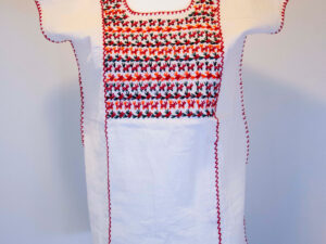 Traditional handmade Mexican embroidered white blouse made of cotton on a mannequin