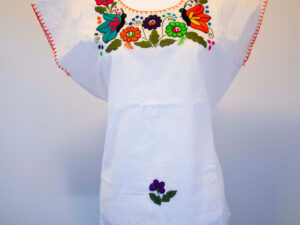 Front view of a Traditional handmade Mexican embroidered white blouse made of cotton on a mannequin